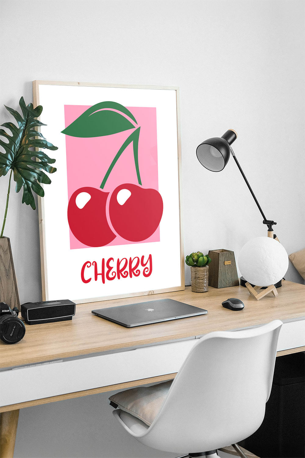 Pembe arka plan üzerinde iki kırmızı kiraz ve yeşil yaprakları olan modern çerçeveli poster