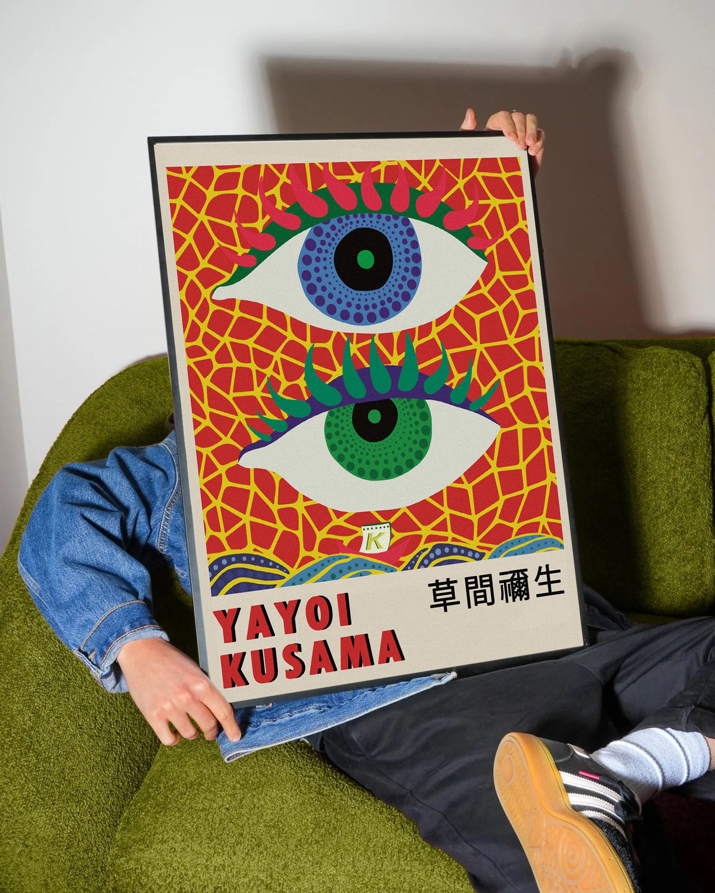 Yayoi Kusama'nın imzası olan, kırmızı zemin üzerinde mavi ve yeşil göz motifli, canlı renkli modern sanat posteri.