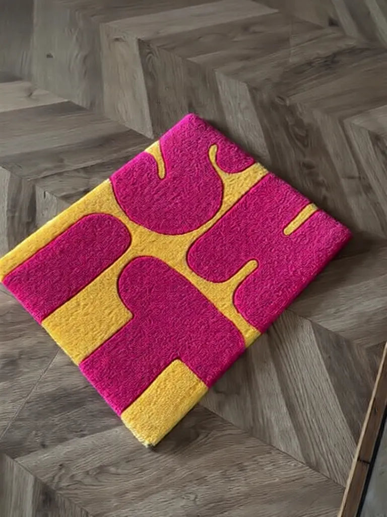 Canlı pembe ve parlak sarı renklerde, 'SHIT' yazısı kabartmalı, el yapımı modern tufting halı.