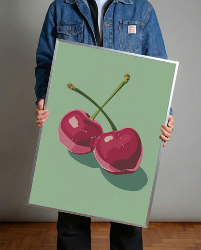 Siyah çerçeveli, açık yeşil fonda iki adet stilize pembe kiraz desenli modern poster.