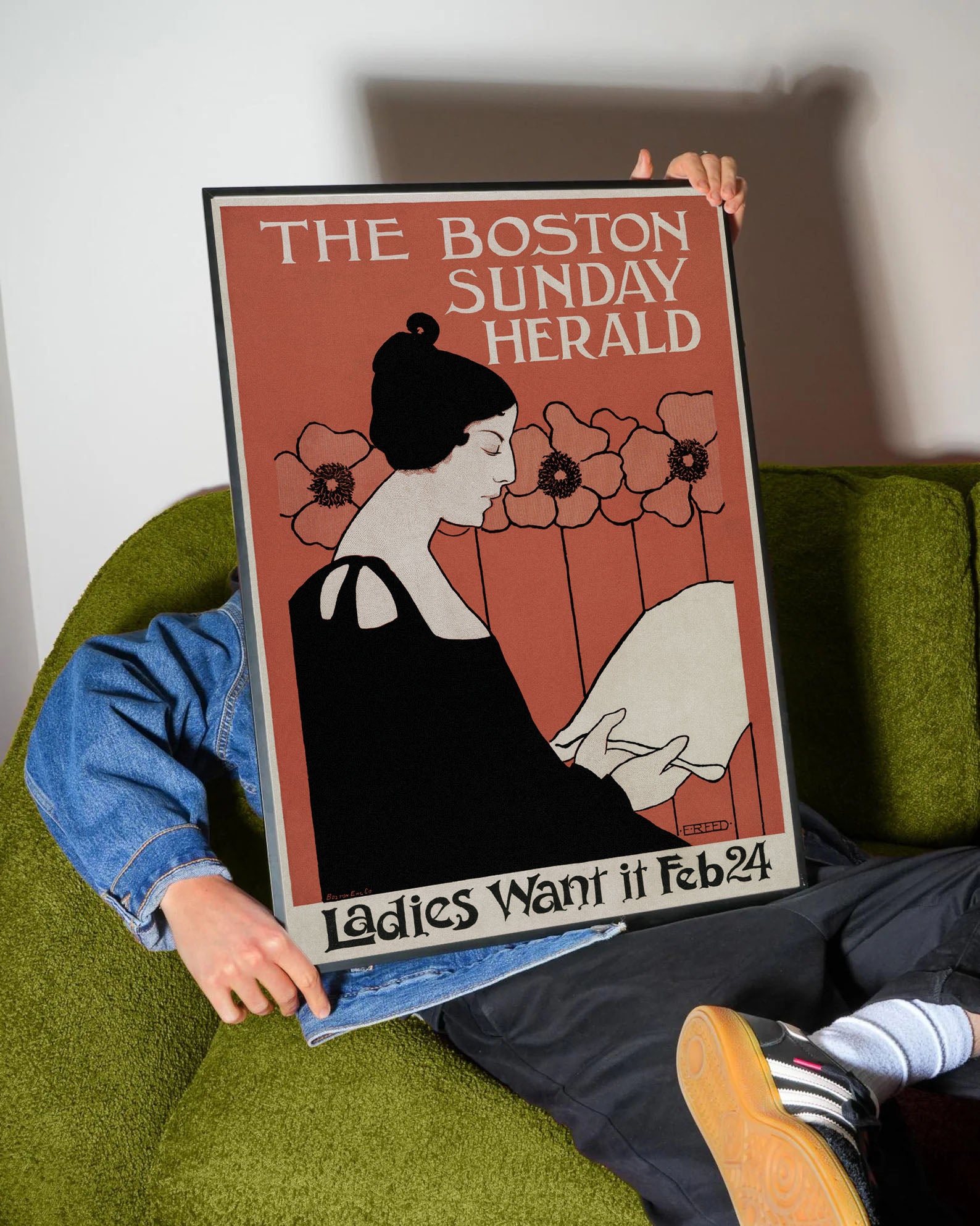 Kiremit rengi fonda, Art Nouveau tarzı siyah elbiseli kadın figürü ve çiçekler içeren Boston Herald vintage posteri.