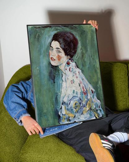 Siyah çerçeveli, Gustav Klimt'in yeşil tonlarda arka plana sahip, renkli fırça darbeleriyle işlenmiş kadın portresi.