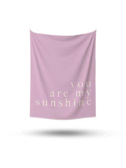 Açık pembe renkte, üzerinde 'you are my sunshine' yazan, minimalist ve modern duvar örtüsü.