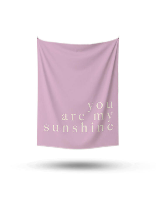 Açık pembe renkte, üzerinde 'you are my sunshine' yazan, minimalist ve modern duvar örtüsü.