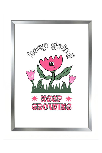 Siyah çerçeveli, beyaz zeminde pembe gülen çiçek, küçük çiçekler ve çimenler ile 'Keep Going' ve 'Keep Growing' yazılı motivasyon posteri.
