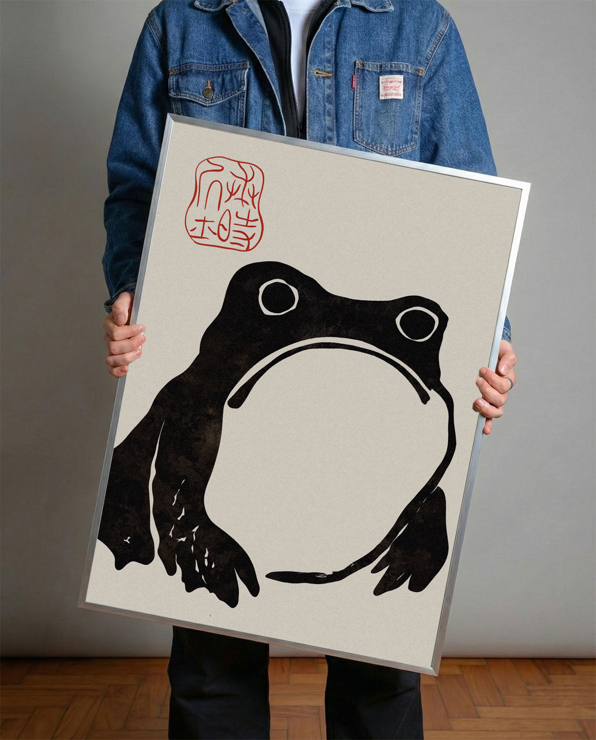 Krem rengi arka planda, dokulu siyah minimalist Japon kurbağa silüeti ve kırmızı mühürlü duvar posteri.