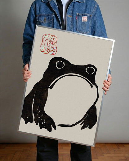 Krem rengi arka planda, dokulu siyah minimalist Japon kurbağa silüeti ve kırmızı mühürlü duvar posteri.