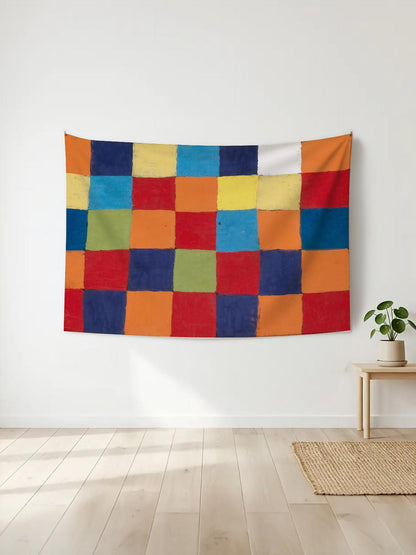 Canlı renklerde, el yapımı hissi veren kareli patchwork desenli duvar örtüsü, beyaz duvarda asılı.