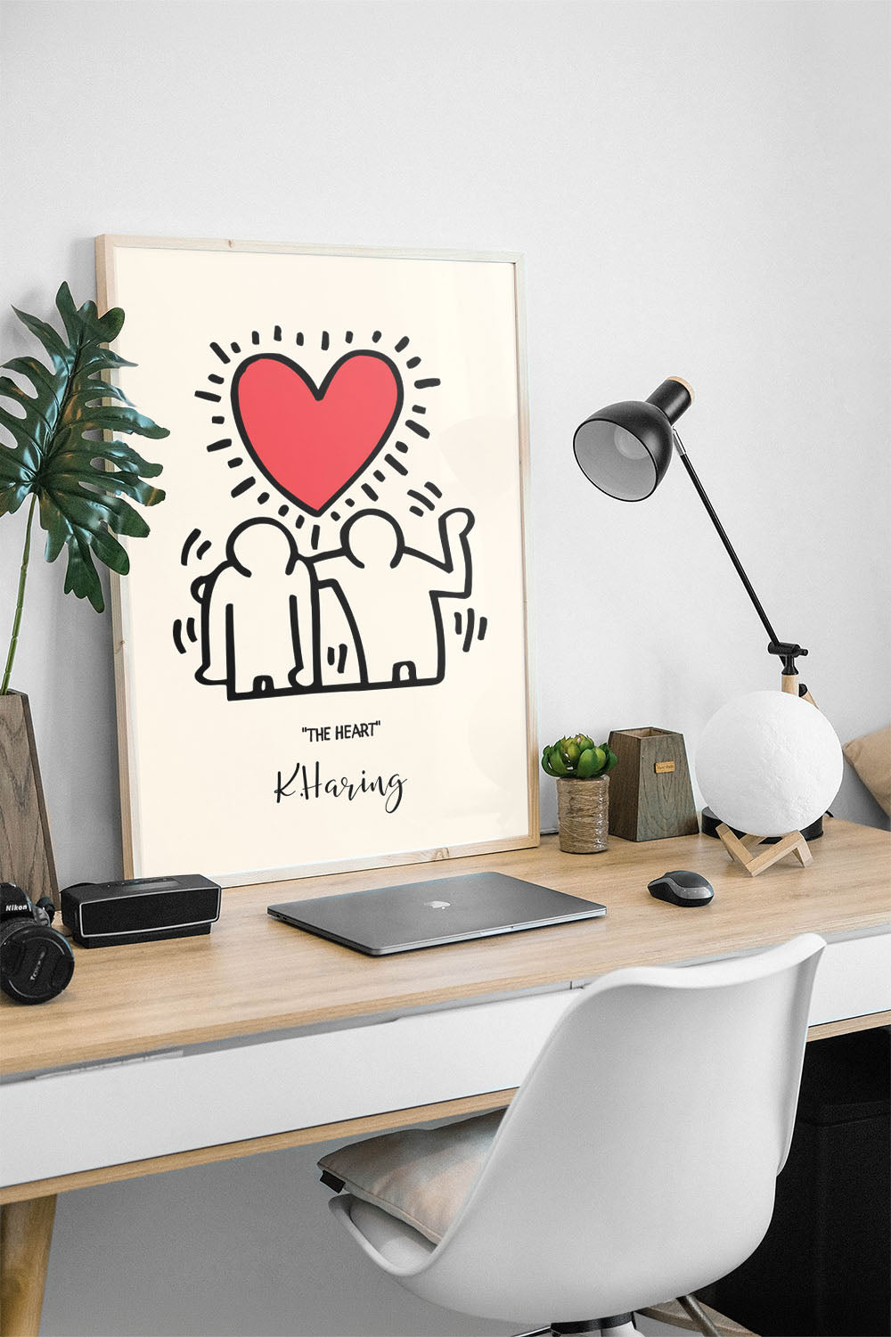 Siyah çerçeveli, bej zeminli, Keith Haring tarzı iki insan figürü ve parlak kırmızı kalp içeren modern sanat posteri.