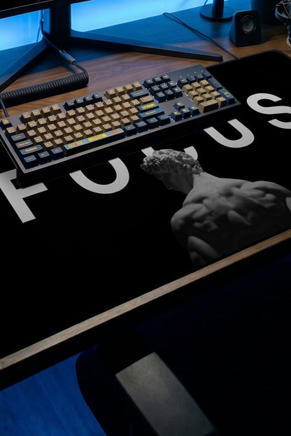 Siyah arka plan üzerinde beyaz FOCUS yazısı ve heykeltıraş figürlü desenli büyük oyuncu mousepad